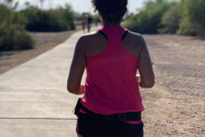 Breanna's back as she runs on a trail.